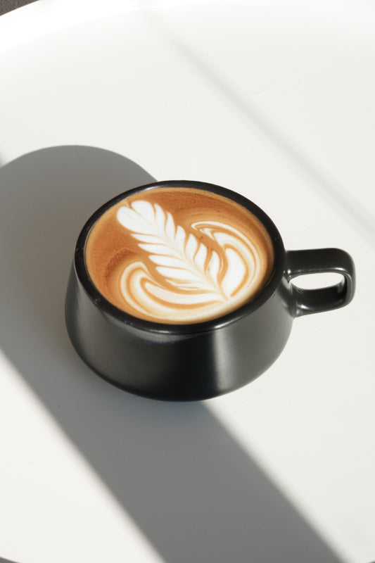 Cappuccino Tasse in schwarz mit Latte Art